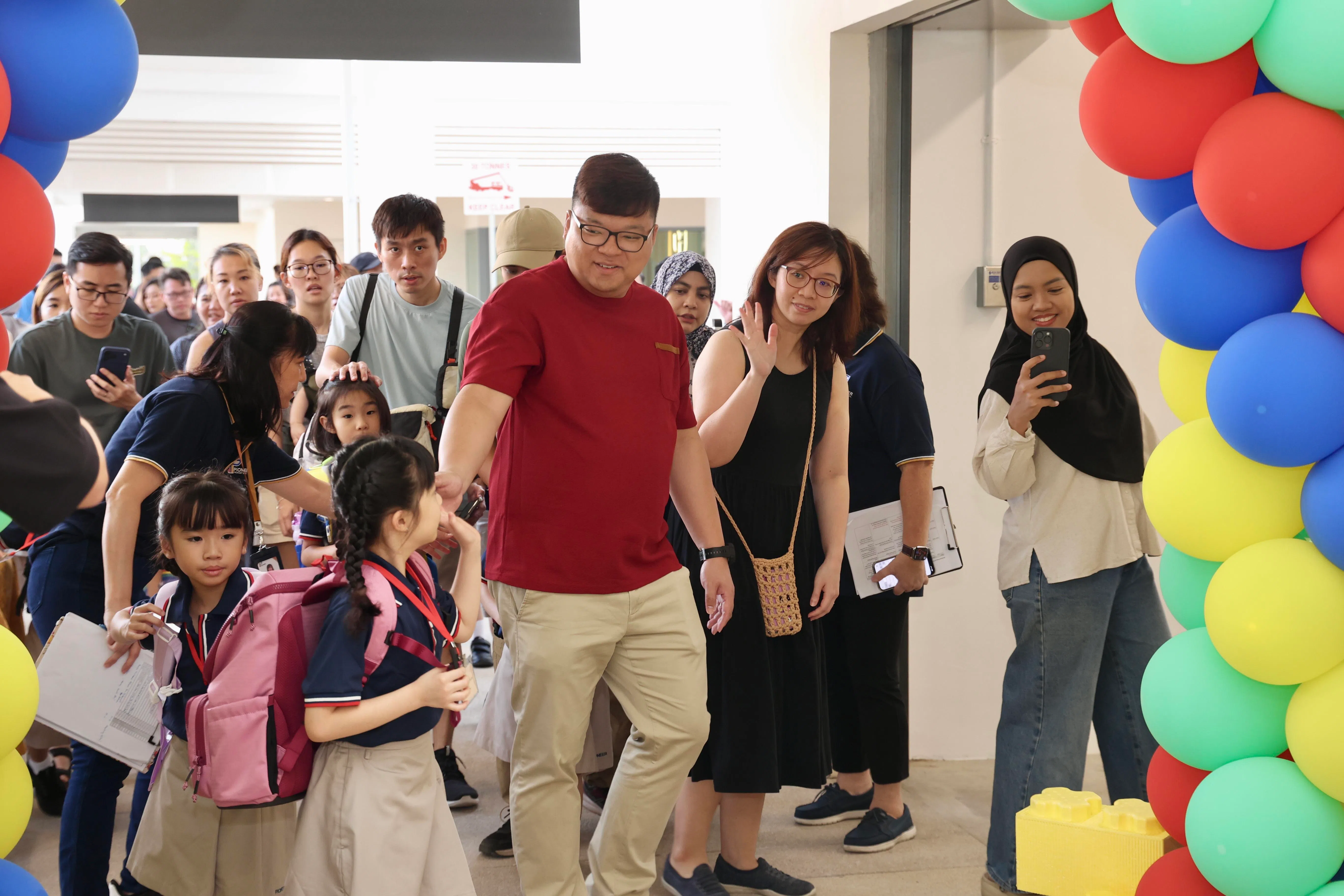 聚英小学一年级新生在家长的陪同下抵达学校，与家长暂时告别后到课室活动，家长则到礼堂听教师分享会，并观赏学生表演。（邝启聪摄）