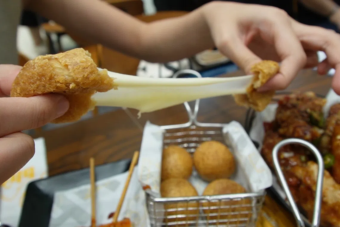 开店促销，购买炸鸡即送芝士球。（王昀诗摄）