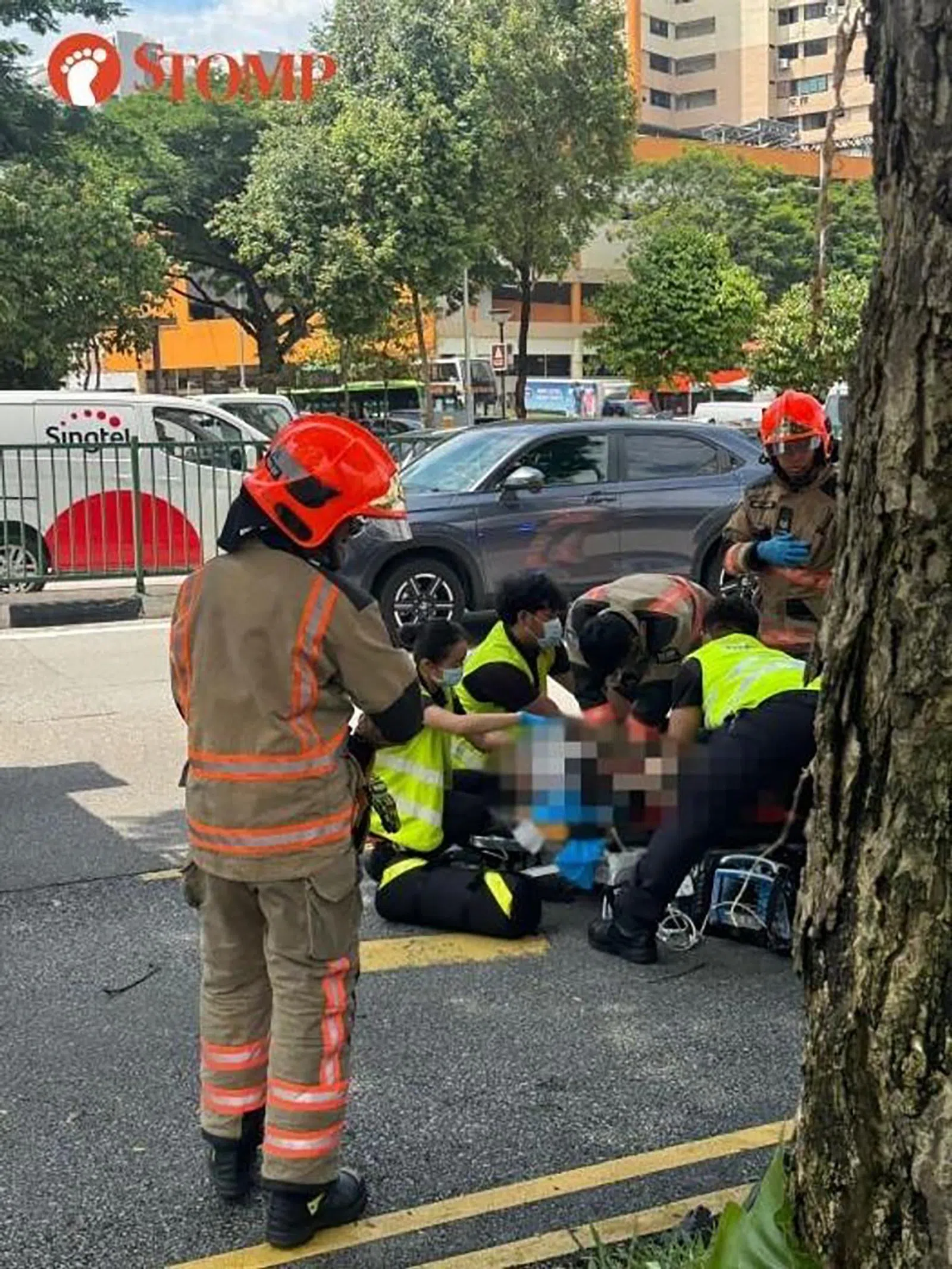 汽车驾驶者躺在马路上，周围有数名救护人员在施予急救。（取自STOMP）