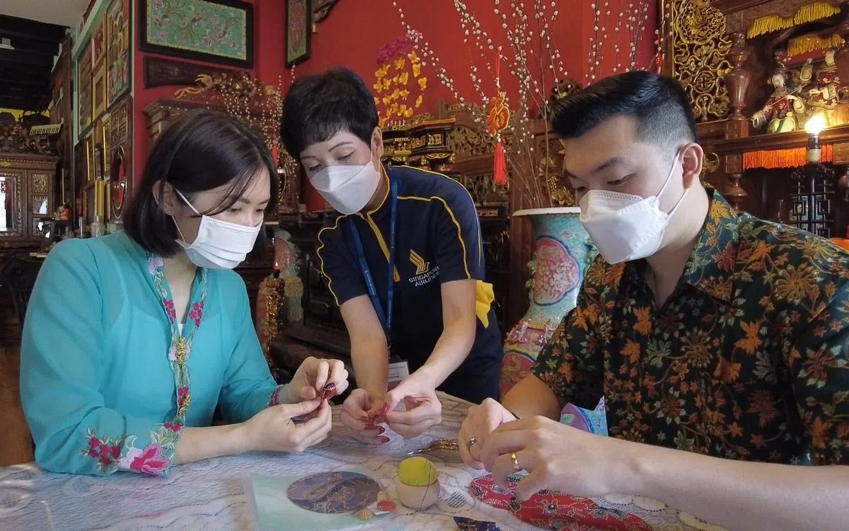 公众可以选择参加手工项目，用新航空服员制服的布料制作纪念品带回家。（视频截图）