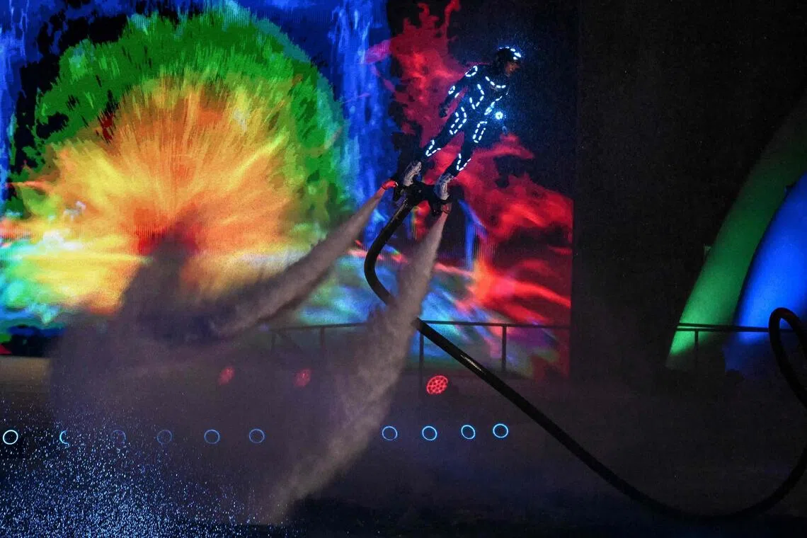 一名穿着水力喷射背包的表演者在空中飞行，呈现精彩绝伦的视觉表演。（法新社）