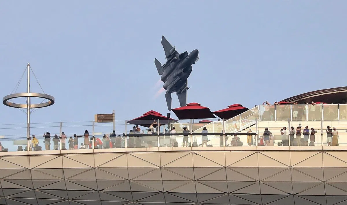 震耳欲聋的战斗机飞过滨海湾金沙空中花园观景台，仿佛触手可及。（何炳耀摄）