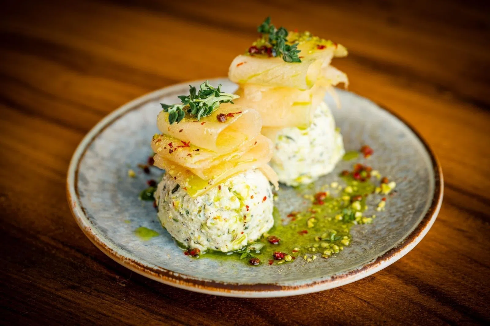 冷前菜Girit Ezmesi使用白芝士制成绵滑抹酱，搭配蜜瓜，鲜香草与烘烤开心果，风味清新细腻。（餐馆提供）