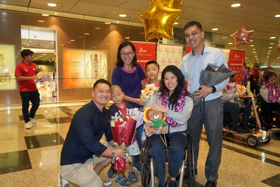 叶品秀（中）的男友冠志（左）和她的哥哥叶建良（右）一家，欢迎叶品秀回国。（谢智扬摄）