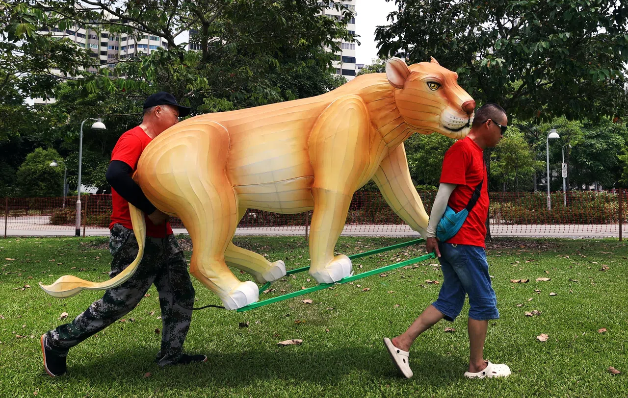 在裕廊湖花园，师傅们忙着搬运一组名为“野生动物奇遇记”（Wildlife Odyssey）的灯饰，图为其中的狮子灯饰。（白艳琳摄）