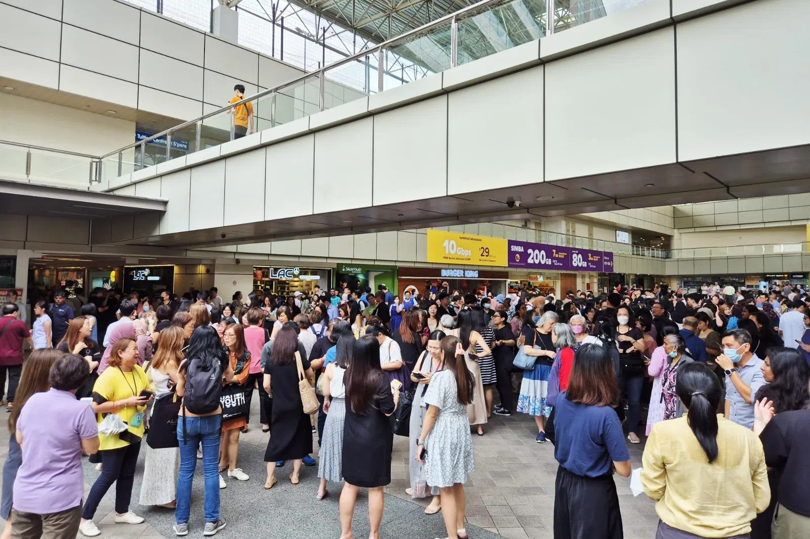 大巴窑建屋局中心停车场失火，大批民众疏散至广场等候进一步指示。（李天錡摄）