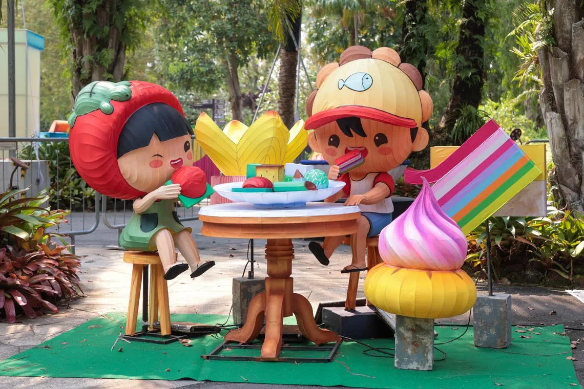 公众沿途可以欣赏到“我们的甘榜精神”“我们的欢聚时光”等以组屋生活、杂货铺为灵感的灯饰造型，看红龟粿女孩和她的好友提灯嬉戏其间，玩着传统游戏、吃着传统美食。（吴先邦摄）