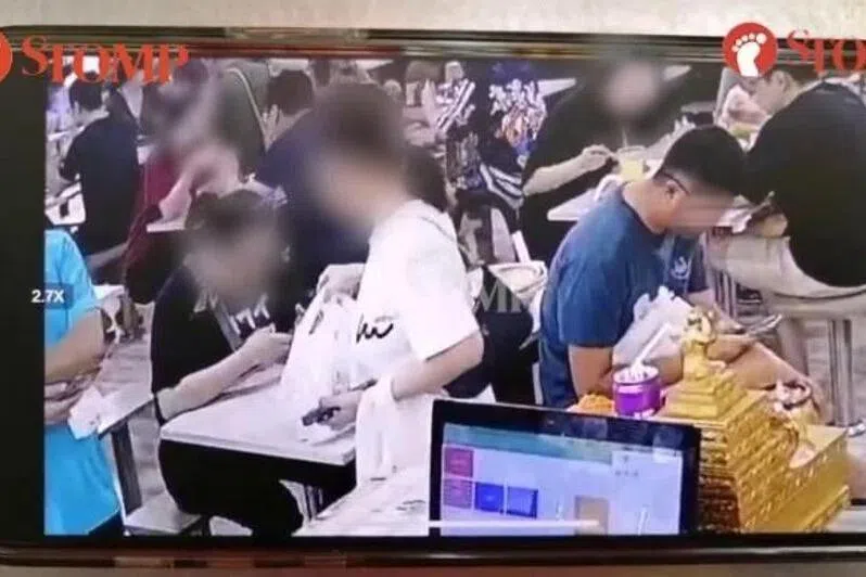 身穿蓝衣的男子事发前一直低头玩手机。（取自STOMP）