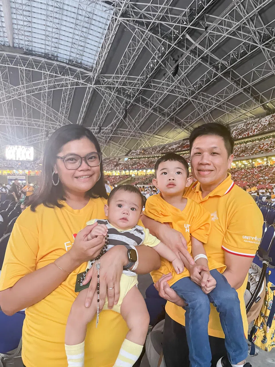 坎拉斯 （左） 和丈夫李征卫（39岁，业务流程专家） 带着两名分别六个月和五岁大的儿子，一同出席弥撒，其中小儿子有幸得到教宗赐福。（李庚洧摄）