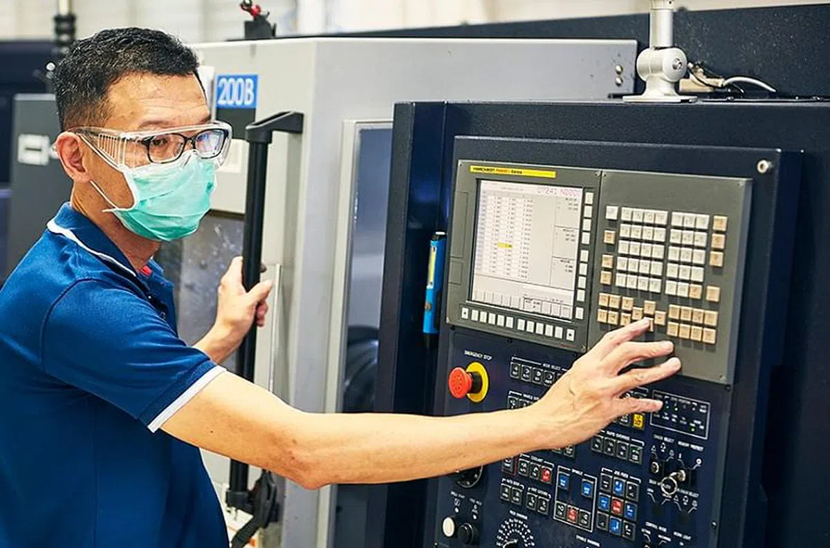 前汽车销售员罗荣庆没有精密工程业的经验，不过电脑化和自动化让培训更容易，新工作很快就能上手。（图/新报业媒体）