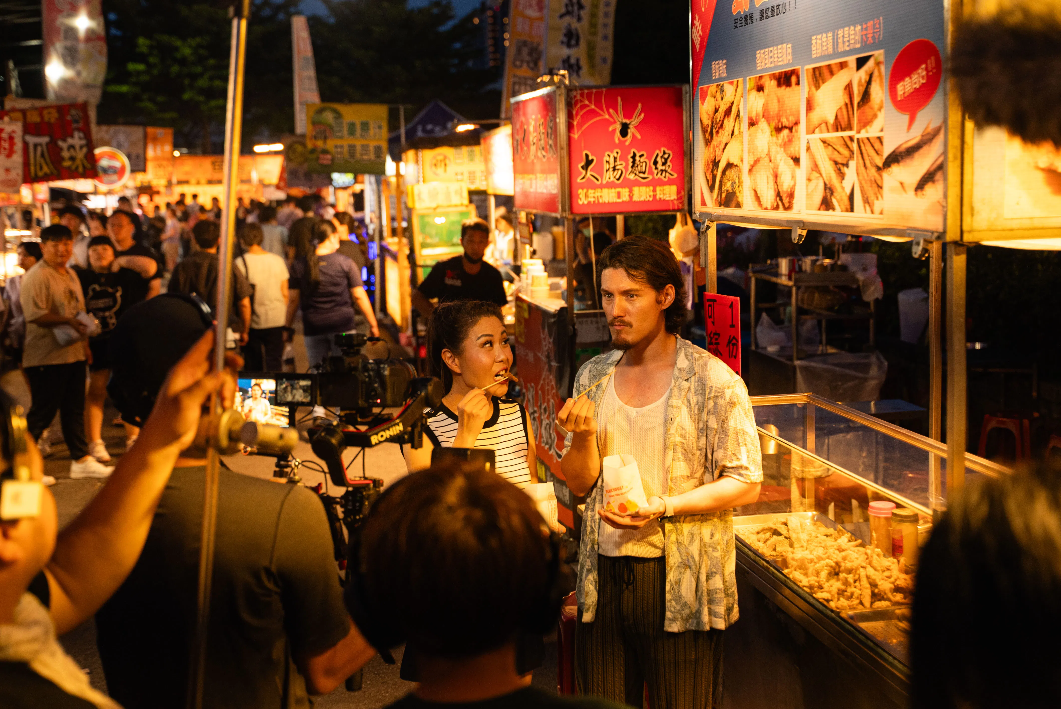 周厚安（右）和郑之芳在台湾的夜市介绍地道的小吃。（新传媒提供）