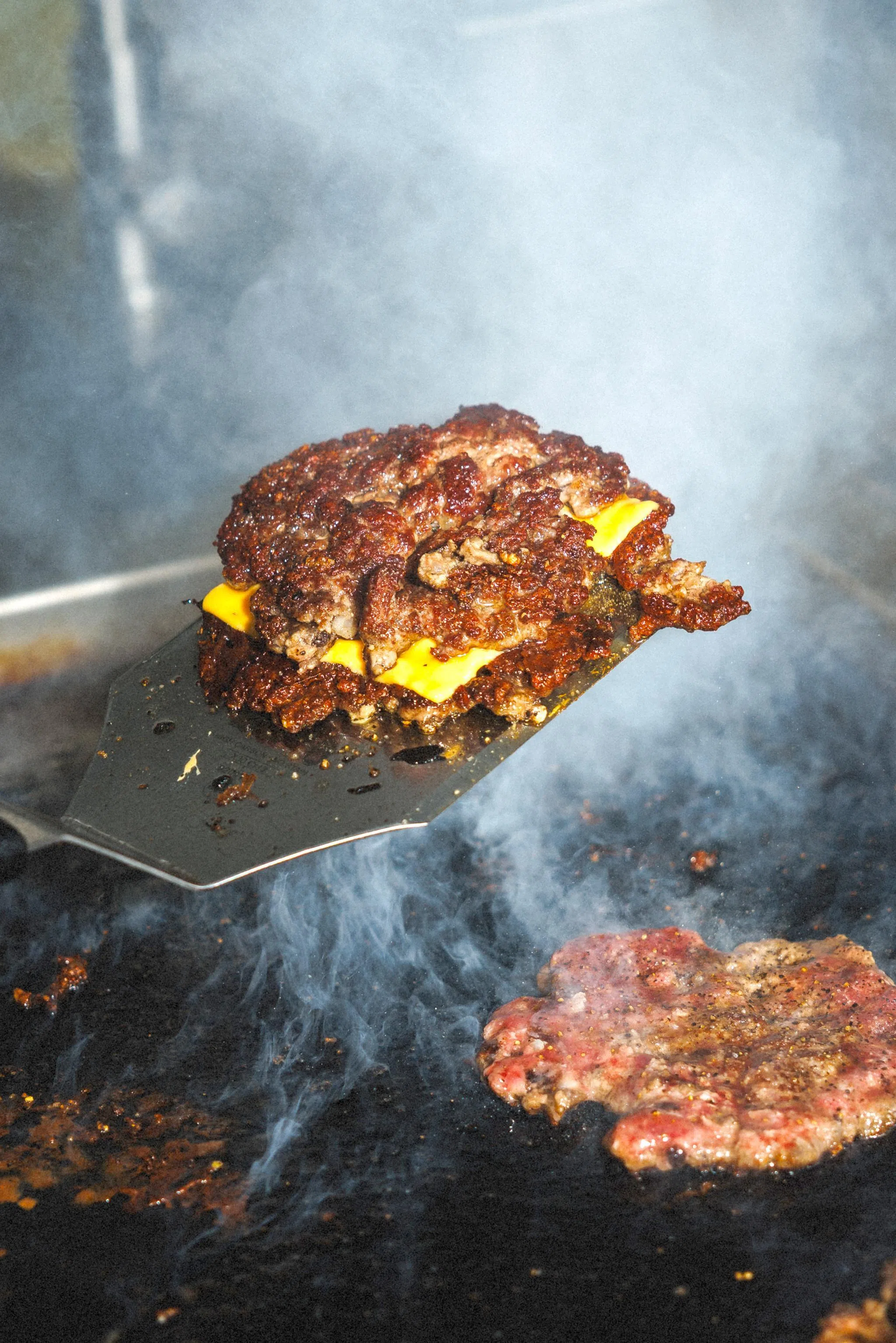 用高温铁板压制煎烤的牛肉饼，边缘焦脆，肉汁被锁住。（餐馆提供）