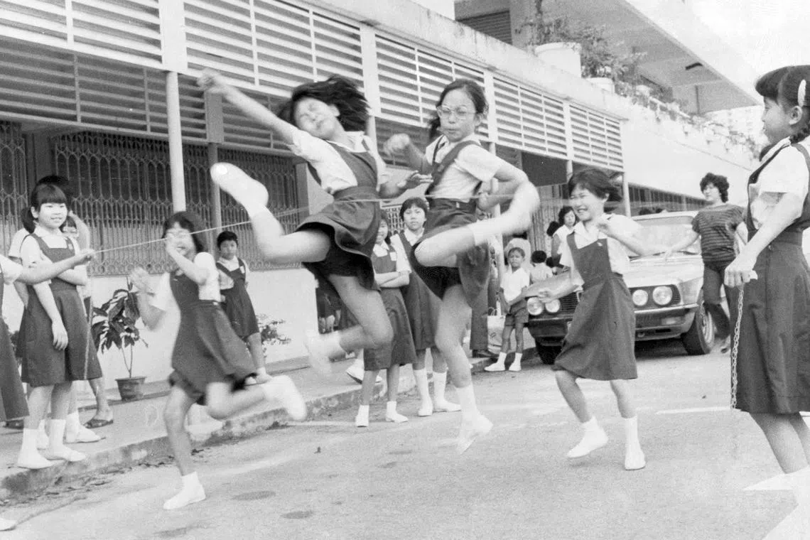 “Zero Point”是当年校园流行的游戏，两人拉起塑胶圈串成的绳子，挑战者一关关跃过。无忧的年纪，开心写在脸上。（档案照片）