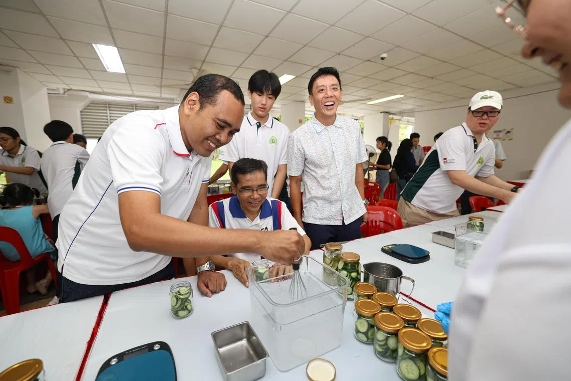 蔡厝港集选区议员萧振祥（右二）和周凯年（左一）向工作坊的讲员和参与者，了解食品保存的秘诀。（关俊威摄）
