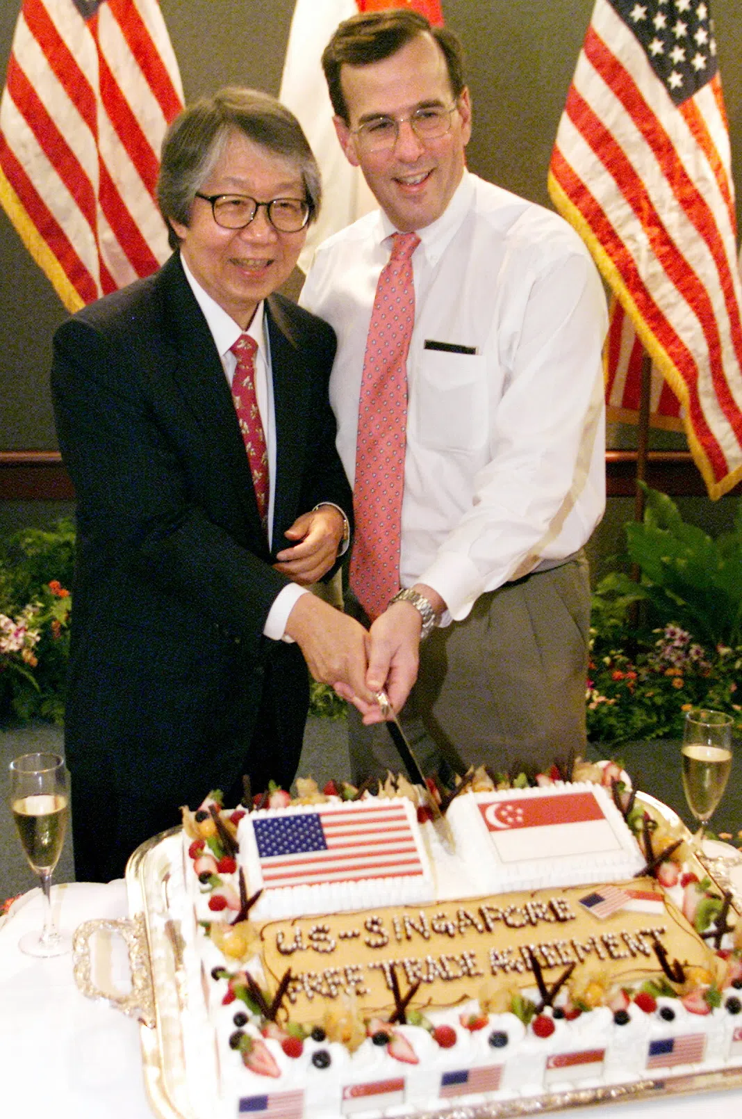 美国参议院2003年以大多数票通过新美自贸协定后，时任美国驻新加坡大使雷文凯（右）在大使馆举行小型庆祝会，许通美到场与雷文凯一同切蛋糕。（档案照片）