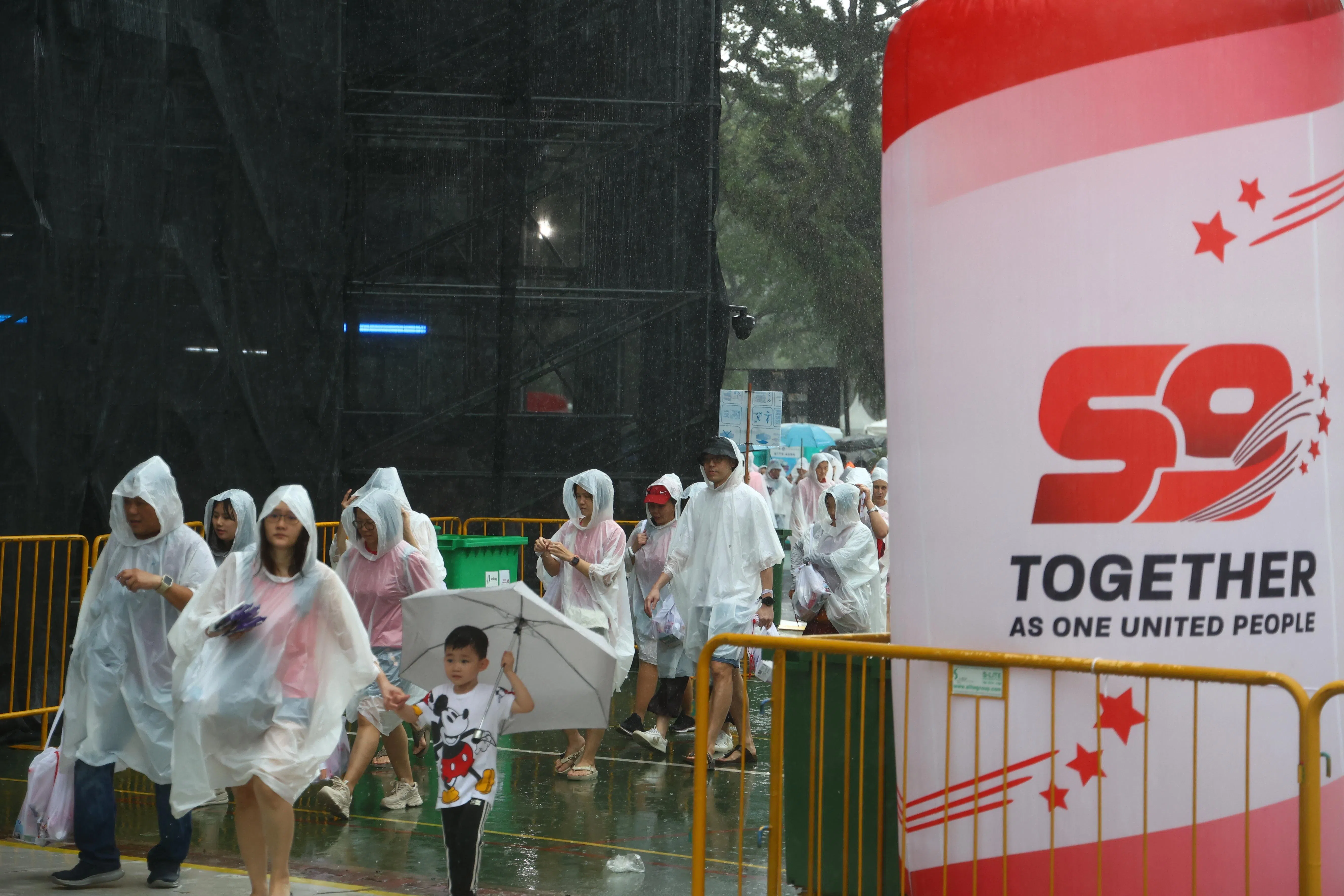 会场突降暴雨，但民众热情不减，仍在雨中入场。（林明顺摄）