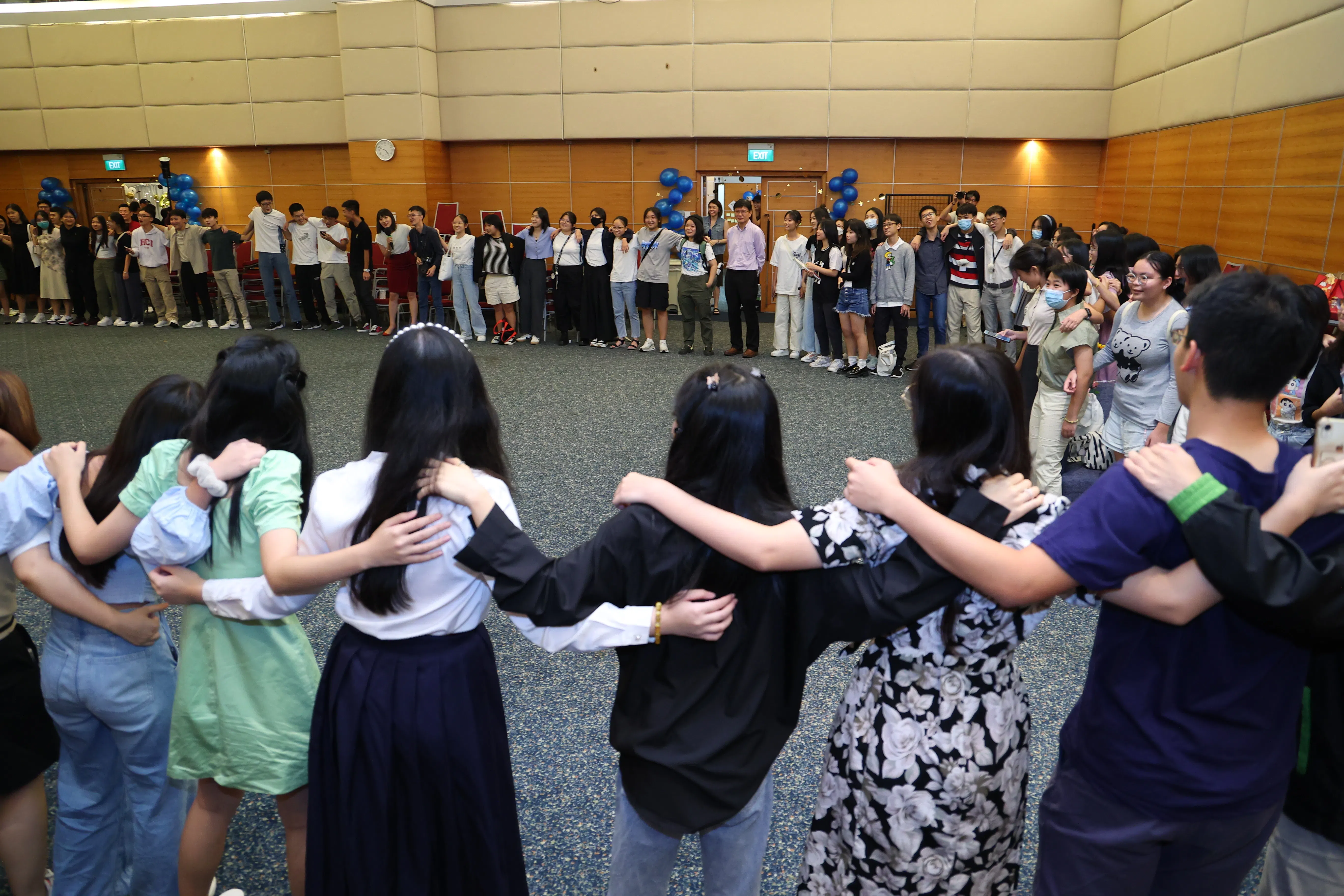 典礼结束后，新旧学生通讯员围成一圈唱起了会歌《友谊保鲜法》。（林明顺摄）