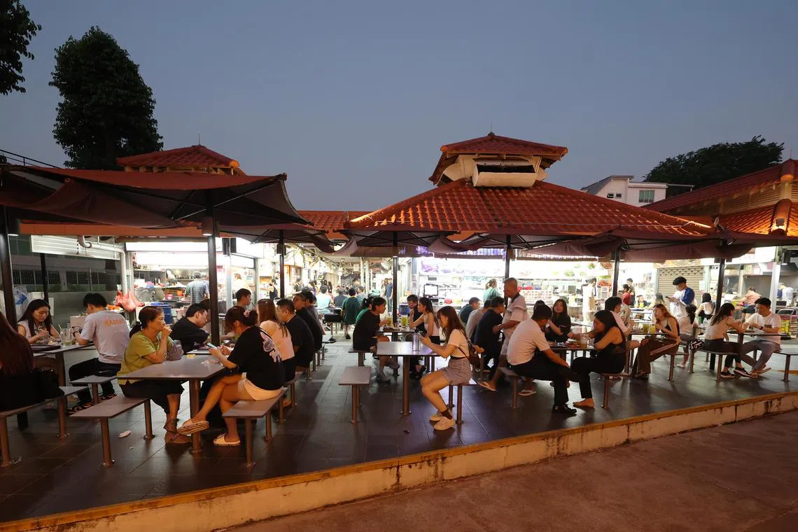 入夜后的忠忠熟食中心，开始热闹起来，不少人喜欢在露天餐区用餐。（唐家鸿摄）