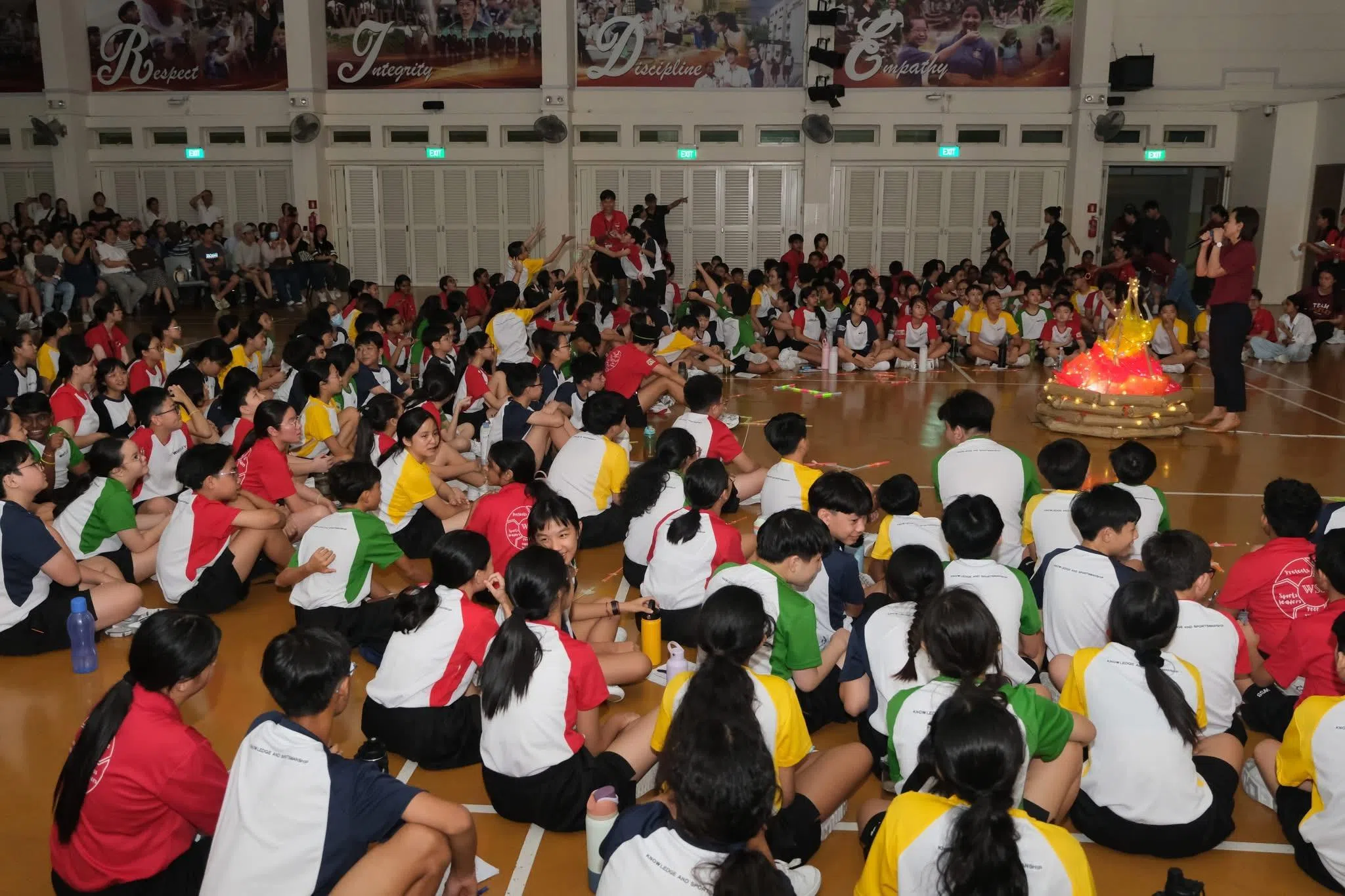 中一学生齐聚室内篝火晚会，聆听校长许琳发言，回望迎新旅程，为“惠厉之旅”画下温馨句点。（惠厉中学提供）