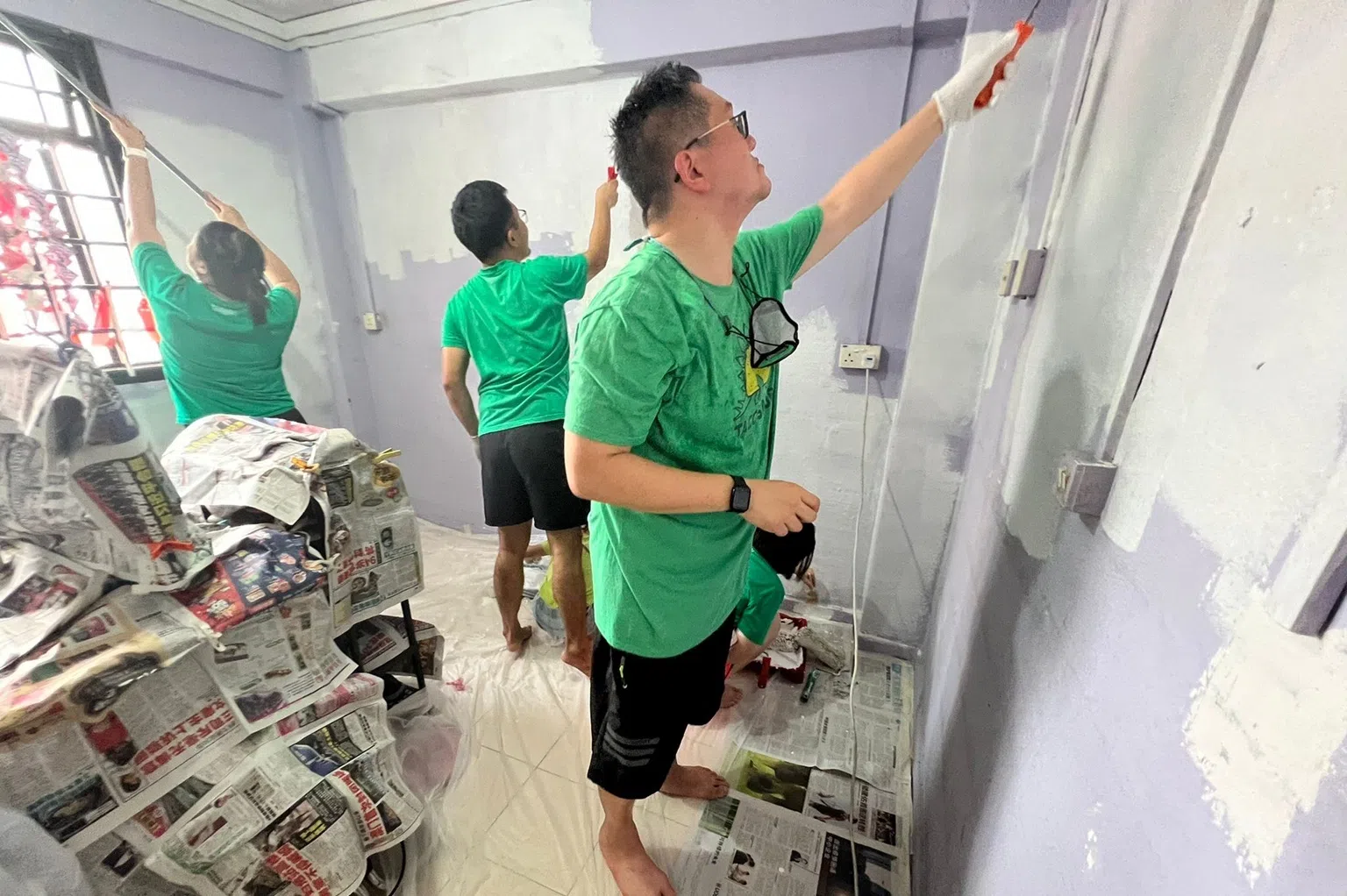 张振铭带领员工担任义工，包括为租赁组屋居民粉刷住家。（受访者提供）