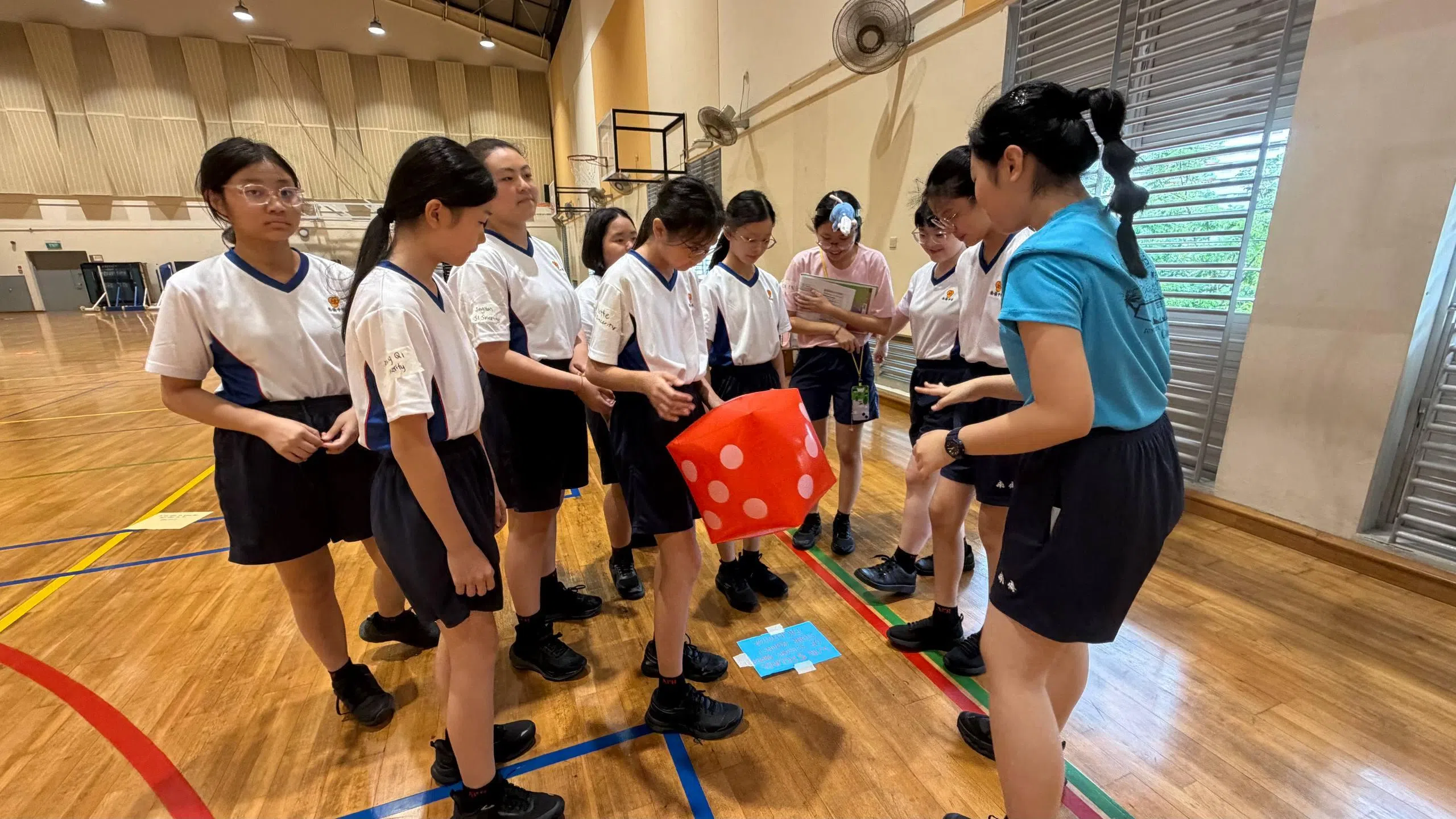 中一新生投掷骰子，在真人版马力欧棋盘上前进。（南侨中学学生理事会宣传部提供）