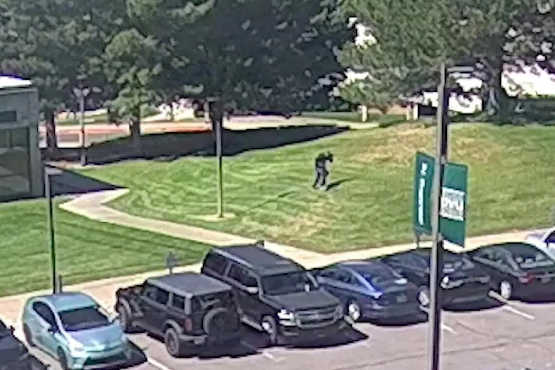 嫌疑人从事发现场附近建筑的屋顶跳下后，穿过停车场旁的草地往绿林直奔，逃离犹他谷大学校区。（路透社）