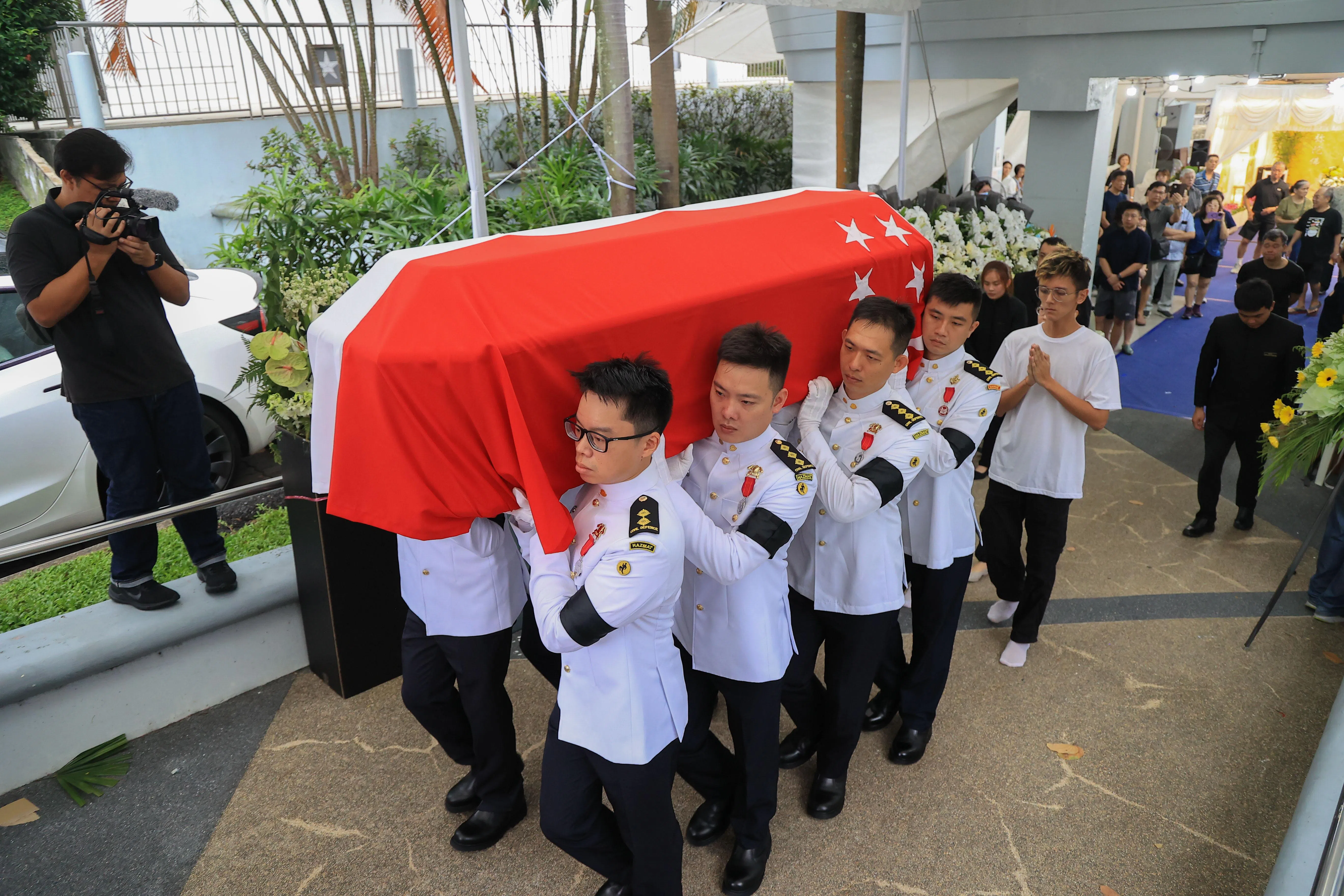 扶灵的八名民防人员分别是郑学勤于民防部队海事消防处第一分区的同僚，以及同届消防队长培训课程的学员。（吴先邦摄）