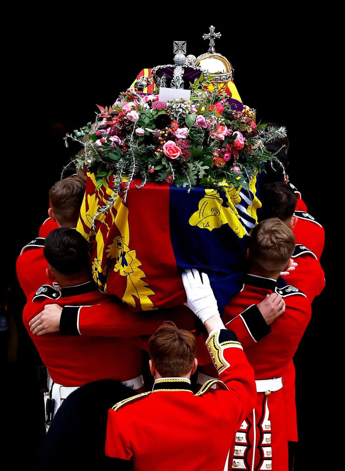 英女王灵柩抵达温莎城堡后，扶灵队伍小心翼翼地将棺木抬入圣乔治教堂。（路透社）