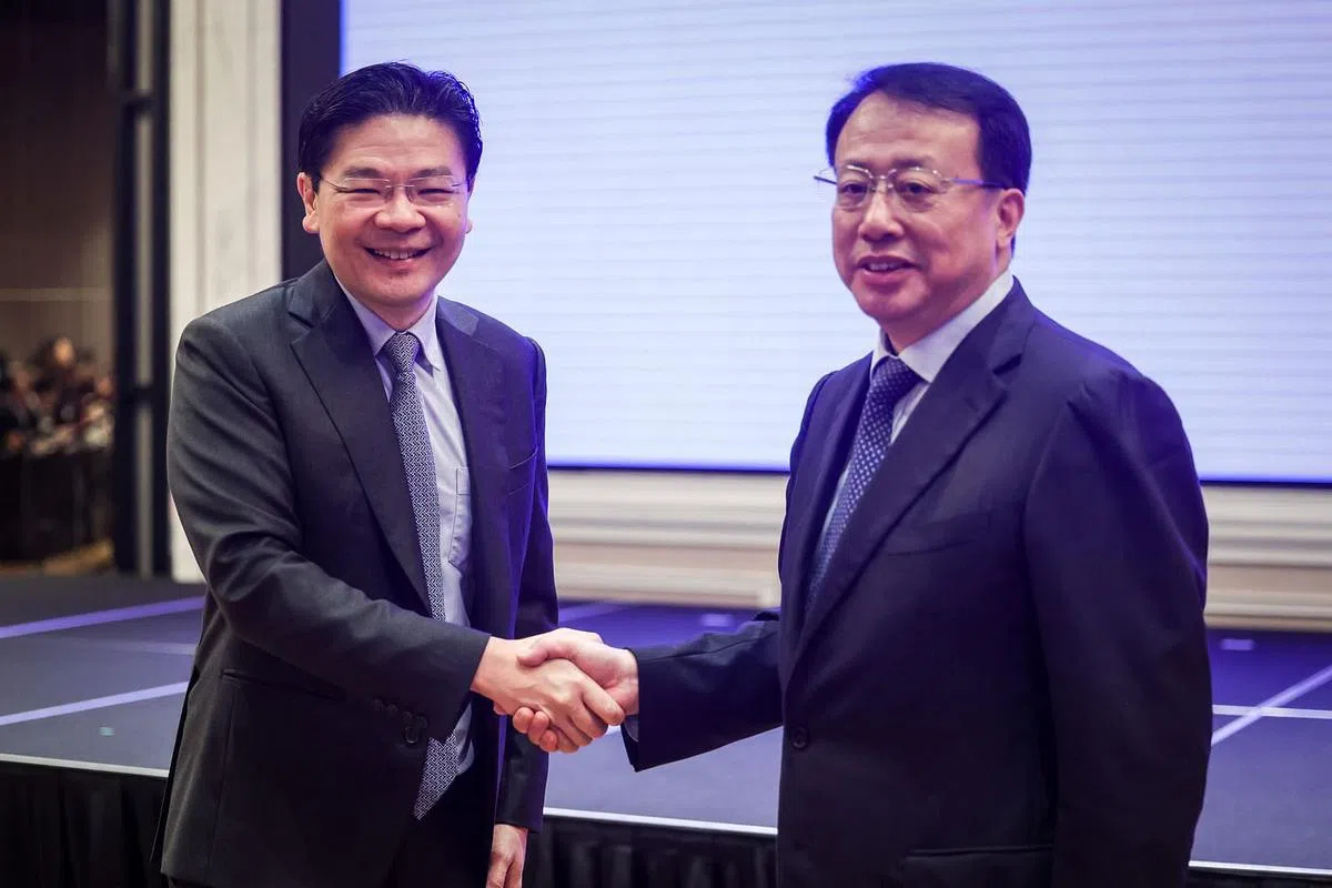 此前担任新沪全面合作理事会新方联合主席的副总理黄循财（左），在致辞后与上海市长龚正握手。两人也在会前进行了会面。（叶振忠摄）