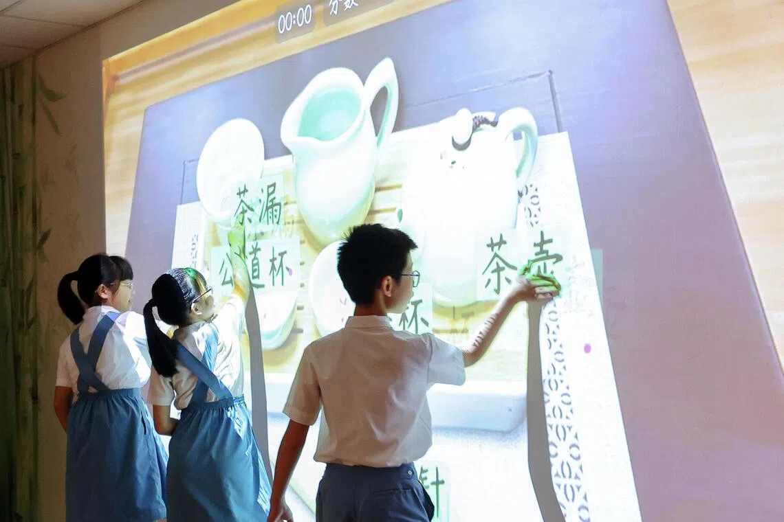 圣婴小学启用科技学习室“文艺苑”，学生不仅和人工智能对话锻炼华文口语、与机器人下围棋，还能通过互动游戏学习茶文化。（游甯稀摄）