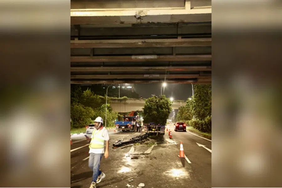 事发后，吊臂装置掉落地面，桥底水泥块碎落，道路布满机油。（邝启聪摄）