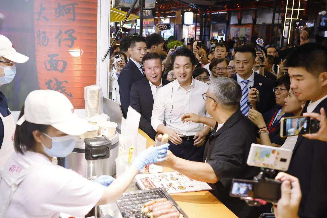 蒋万安星期二晚在上海夜市品尝台湾特色美食。（中新社）