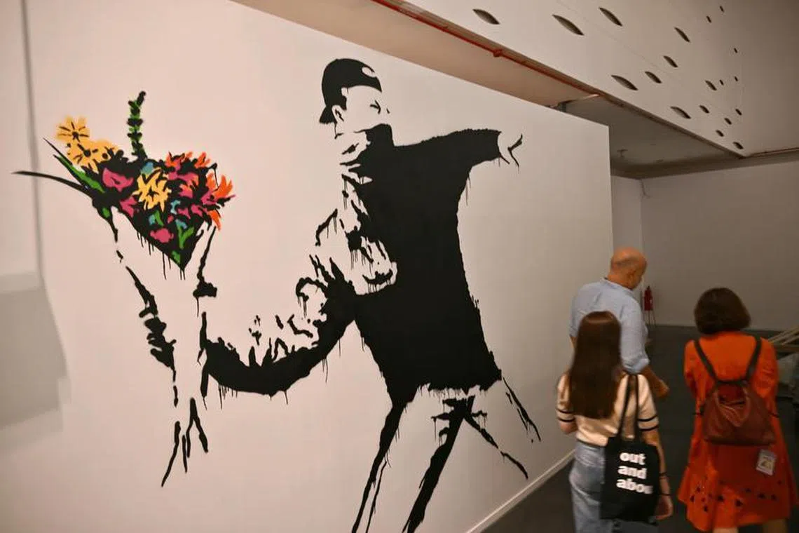 Banksy的经典作品“Flower Thrower”《掷花者》，表达对和平的呼吁。