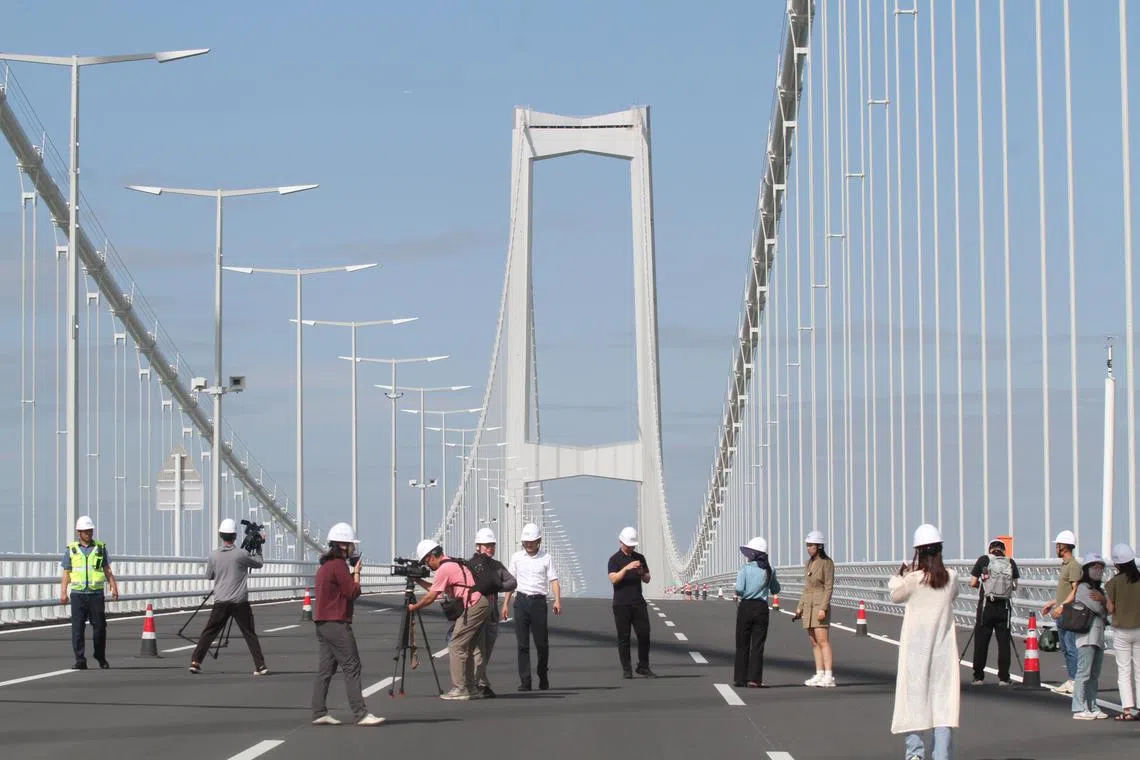 广东省政府外事办公室5月下旬邀请中外记者到深中通道实地采访。图为媒体站在悬索桥，距离海面有91米的最高部分上。（林煇智摄）