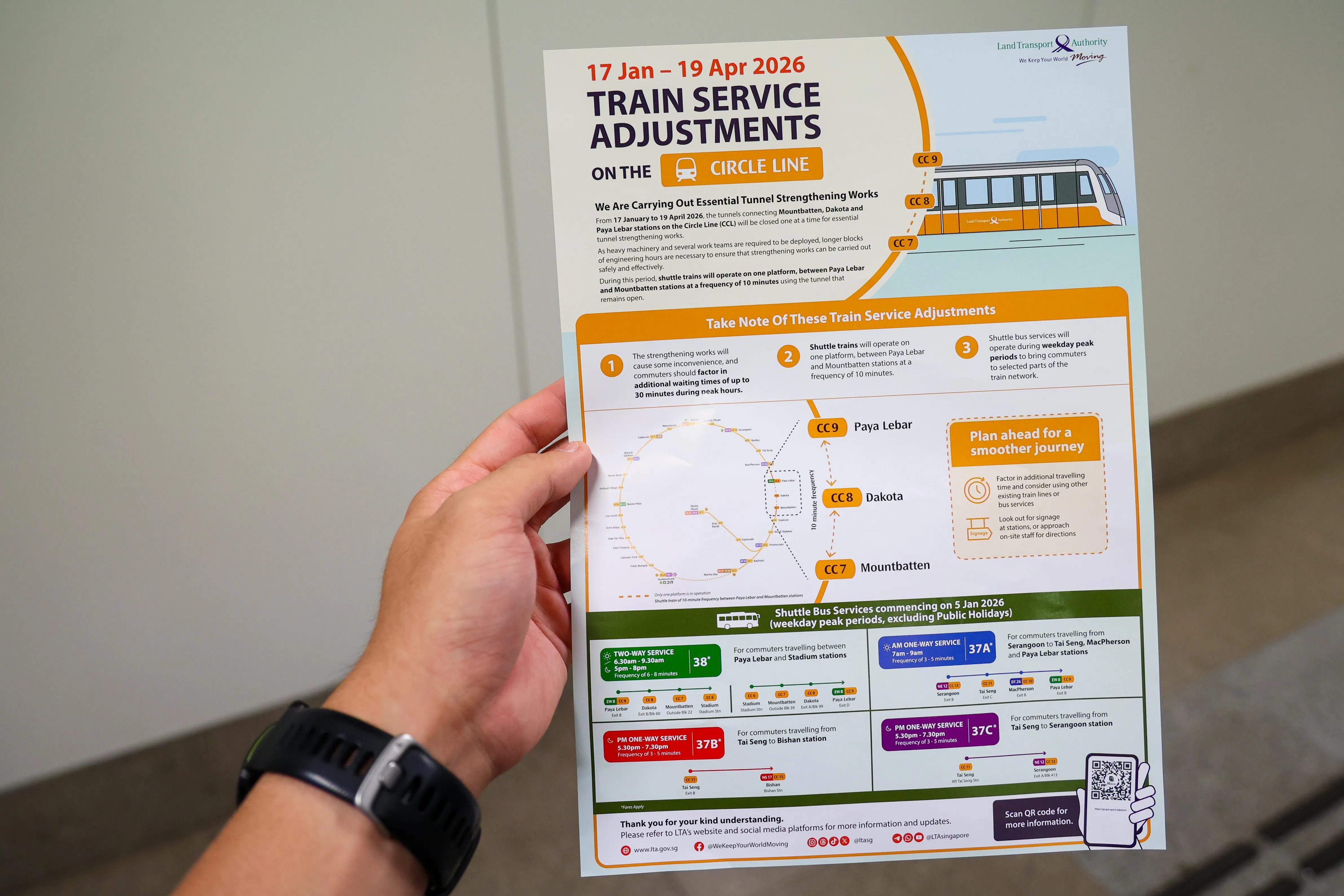 工作人员在实龙岗地铁站分发传单给乘客，通知他们环线接下来的工程，并提供接驳巴士路线的详情。（林明顺摄）