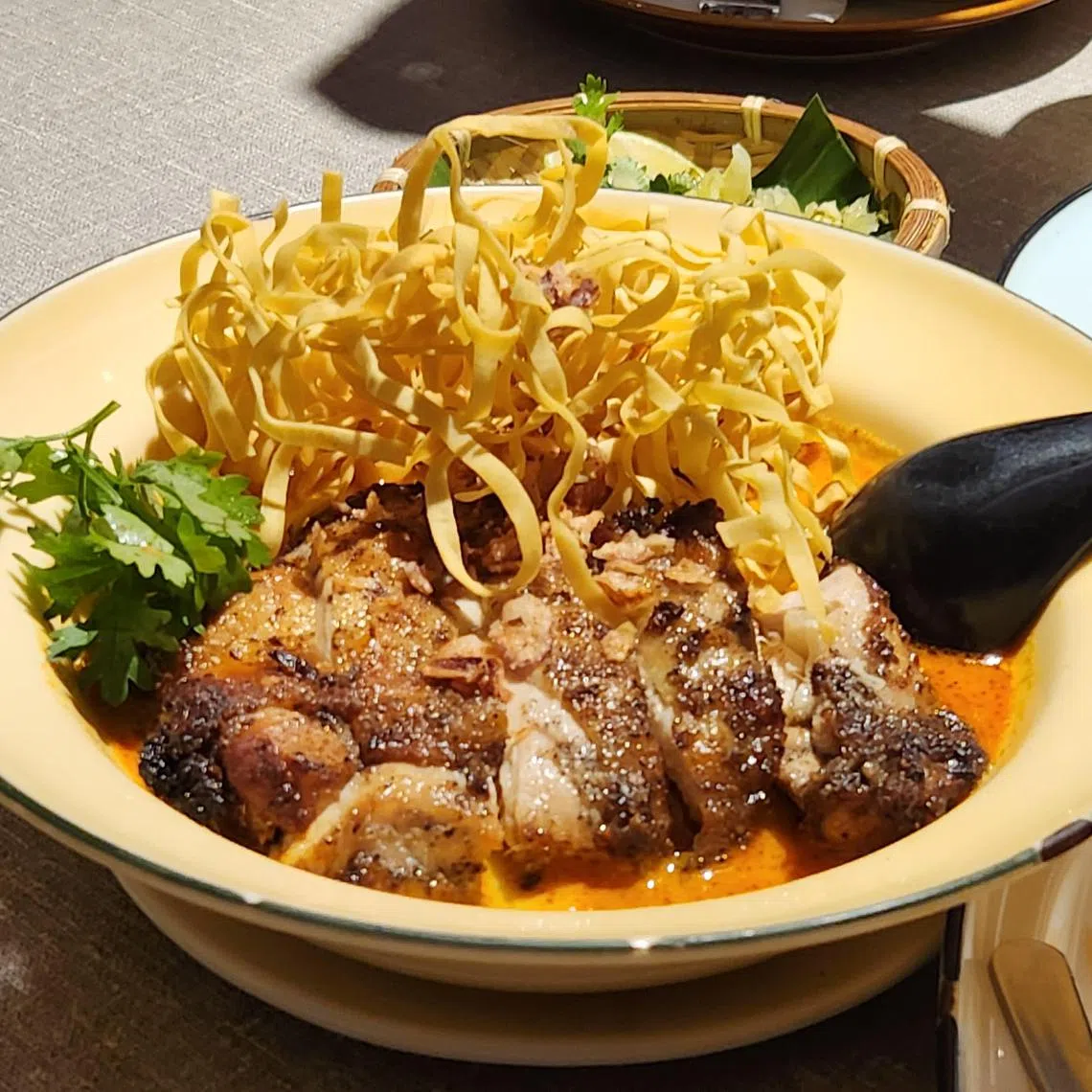 Khao Soi是一面两食的泰北面食，Un Yang Kor Dai版本加了招牌烤鸡。（陈爱薇摄）
