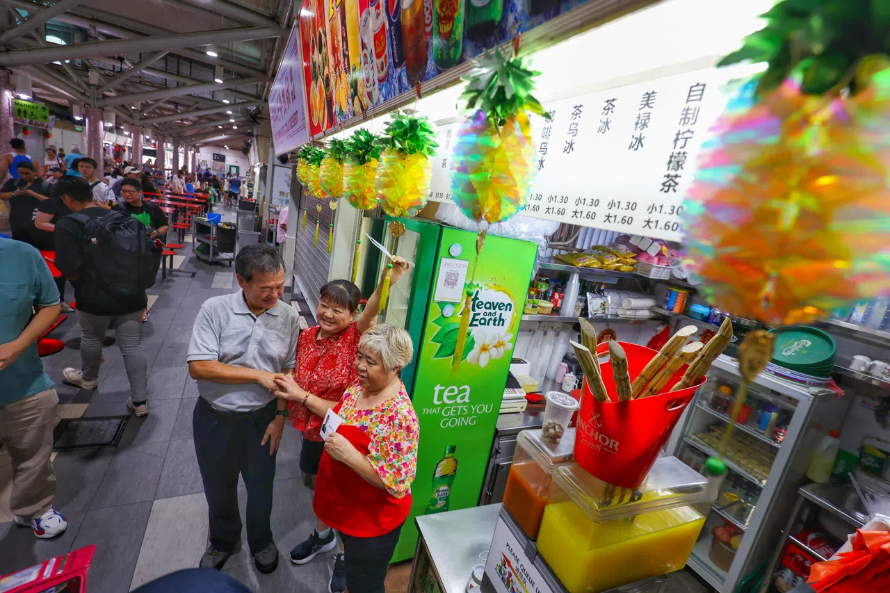 陈钦亮（左一）周三来到惹兰红山的ABC砖厂熟食中心，并与摊贩们交流。（何家俊摄）