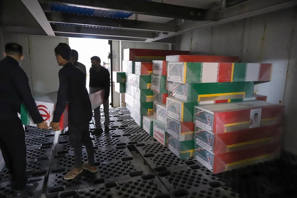 当地人员为遇难者的棺材盖上伊朗国旗。（路透社）