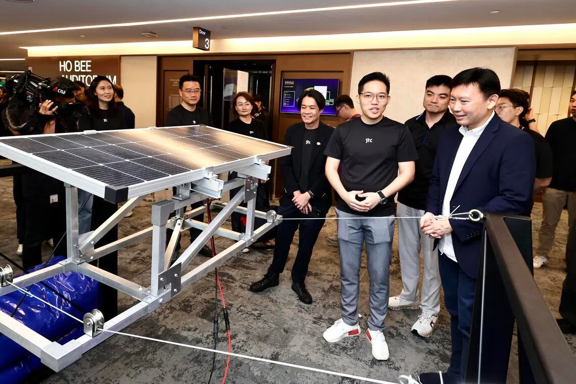 国家发展部长徐芳达（右一）出席公共服务科学科技与工程节， 与参与创新挑战赛的政府机构代表，了解各队伍设计的方案。（周国威摄）