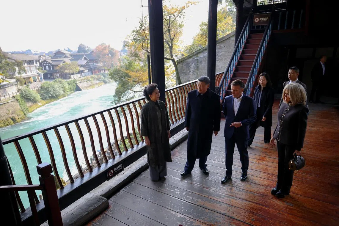 法国总统马克龙（右二）及夫人布丽吉特（右一）在中国国家主席习近平（左二）及夫人彭丽媛在（左一）的陪同下，在四川参观联合国教科文组织世界文化遗产都江堰。（路透社）