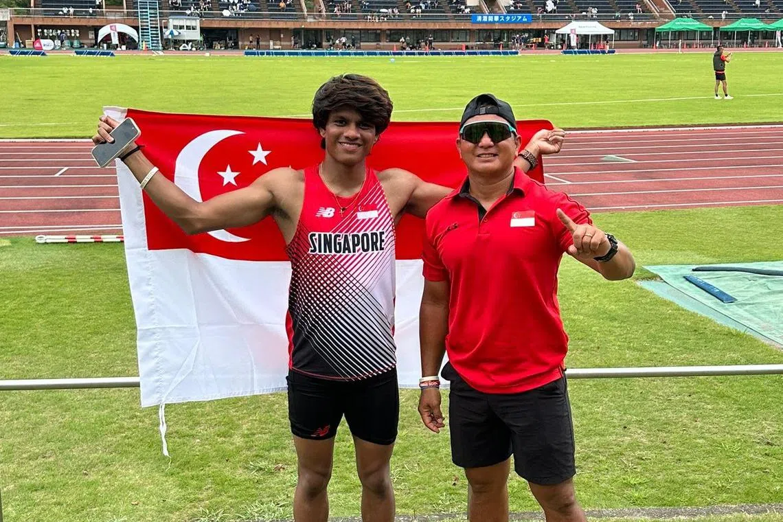 路易斯在打破全国纪录后，手持国旗在赛场与教练余本伯（右）合影。（受访者提供）