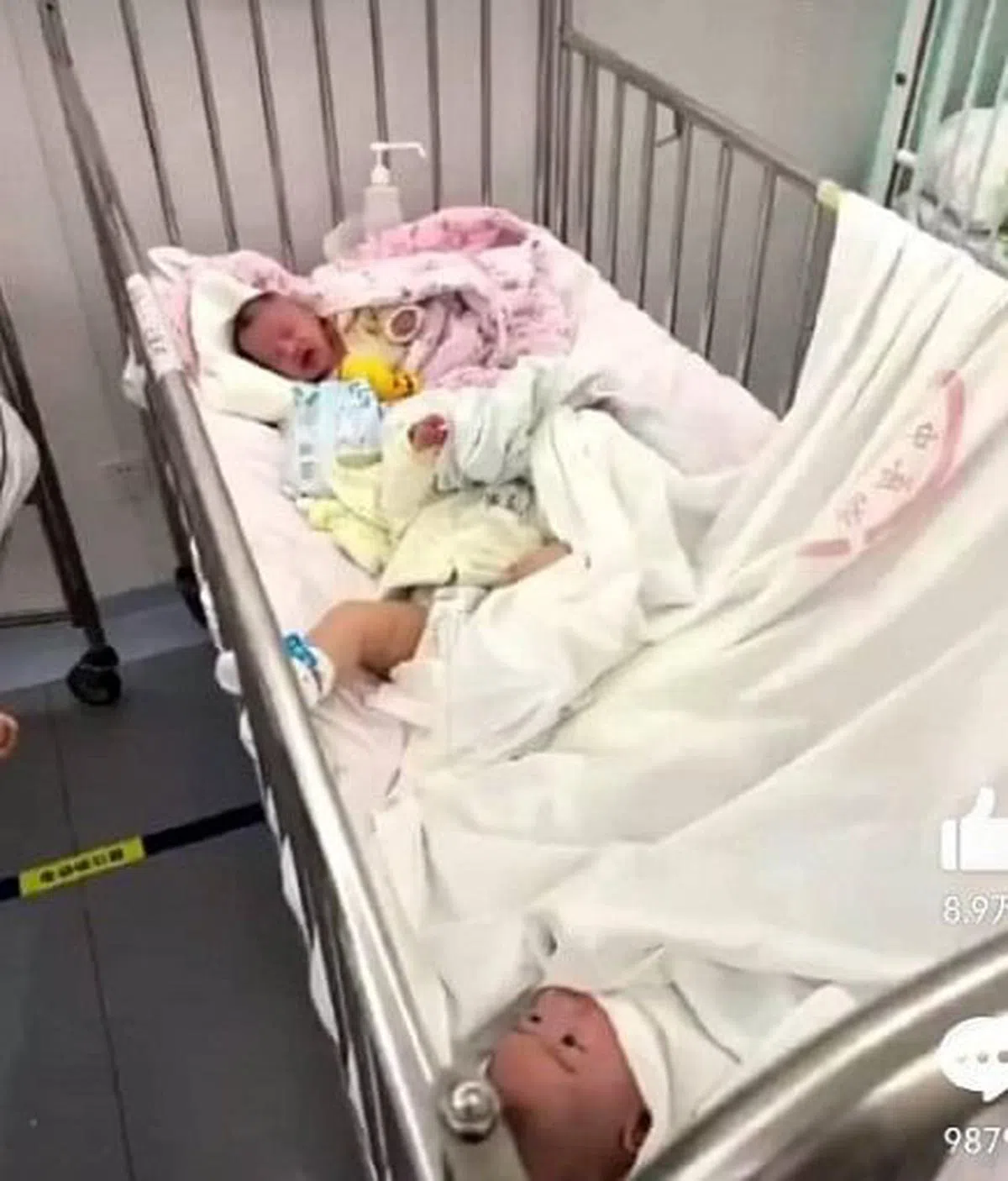 照片显示有婴儿横躺在床尾，被床单蒙住半张脸；有婴儿的旁边放着医院的消毒容器。（互联网）