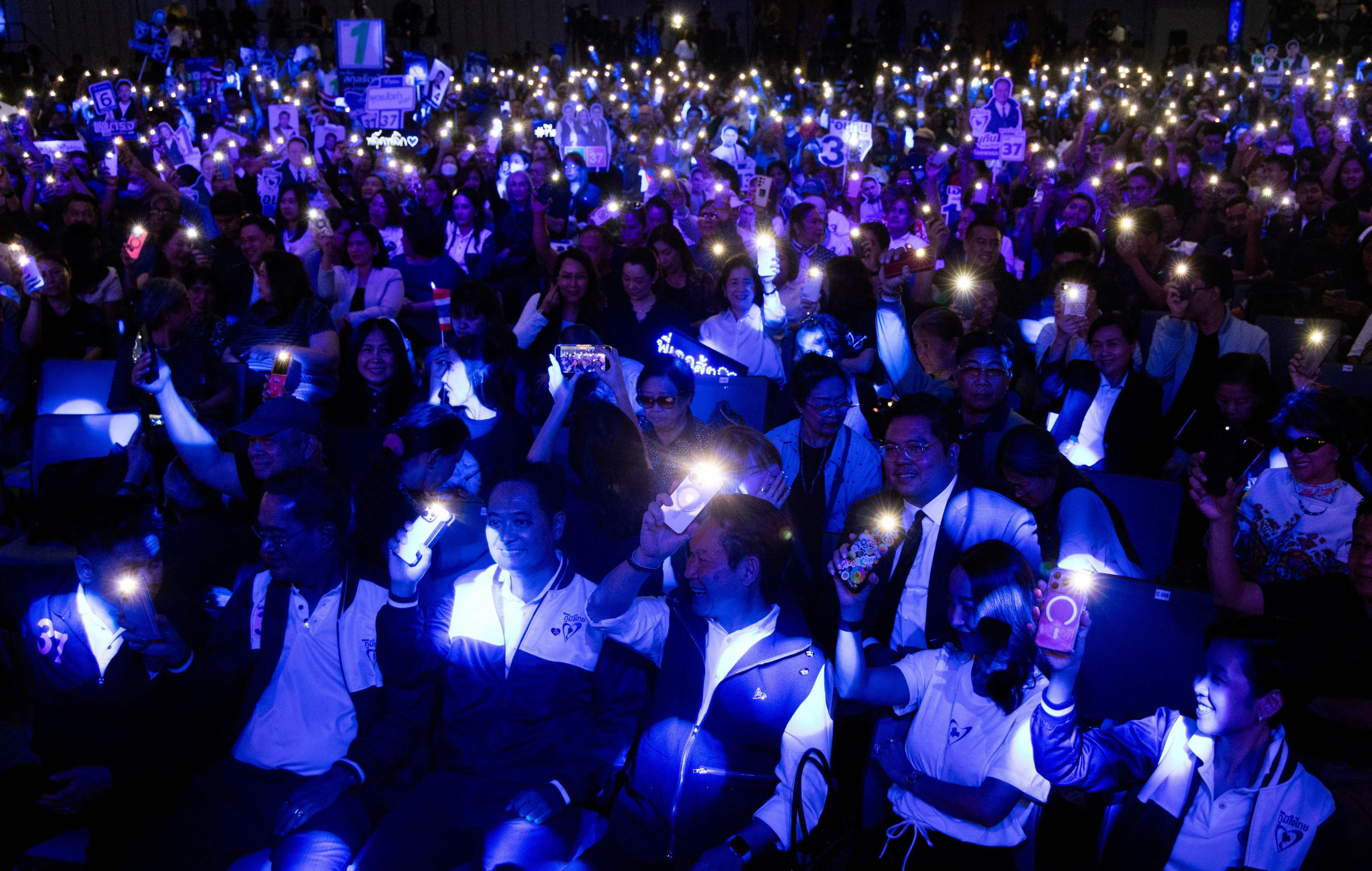 首相阿努廷领导的泰自豪党周五晚在曼谷举行大规模集会，支持者穿蓝色衣服出席，打开手机照明灯，映照出现场一片蓝海。（路透社）