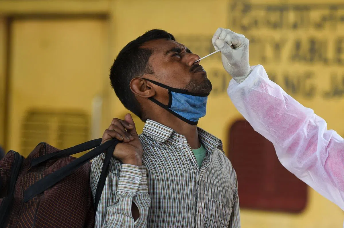 印度医护人员为长途火车乘客进行冠病检测。图：法新社 