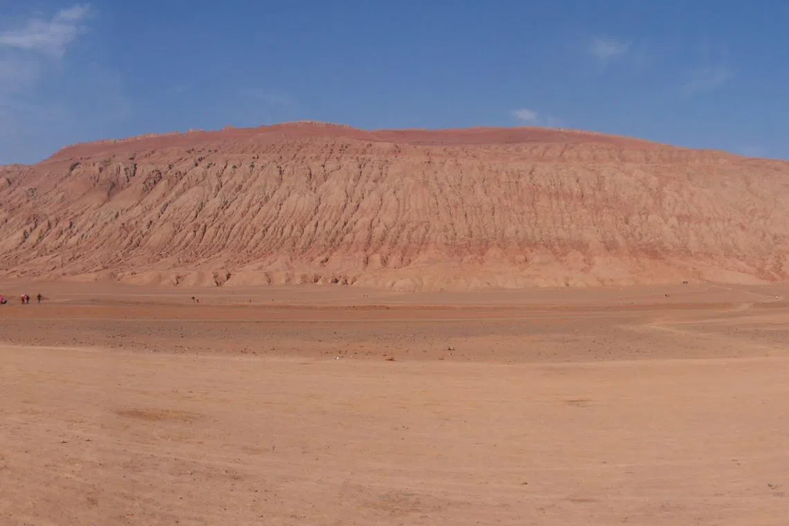 火焰山的赤红色山体，平均高度为500米，垂直紧密排列的沟壑，看起来有些像火苗。