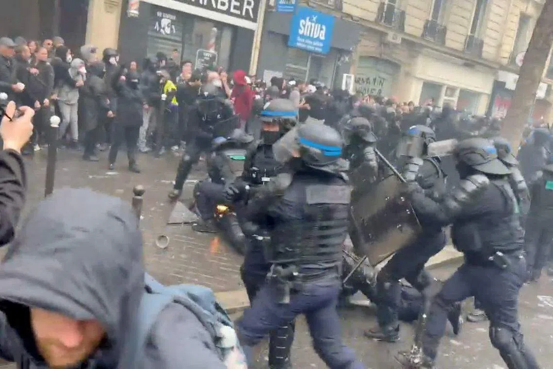 部分示威者朝法警扔掷燃烧弹，图为一名被“点燃”的警察躺在地上由他人协助灭火。（路透社）