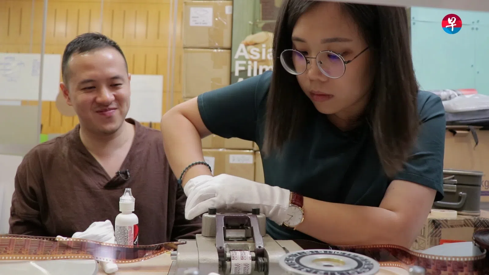 早报数码之前推出《你做哪行？》系列，其中一集介绍AFA电影存档师周世宝（左）教导记者如何衔接修复后的胶片。（档案照）