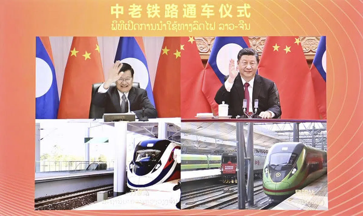 12月3日下午，中共中央总书记、中国国家主席习近平（右上）在北京同老挝人民革命党中央总书记、老挝国家主席通伦通过视频连线共同出席中老铁路通车仪式。（新华社） 