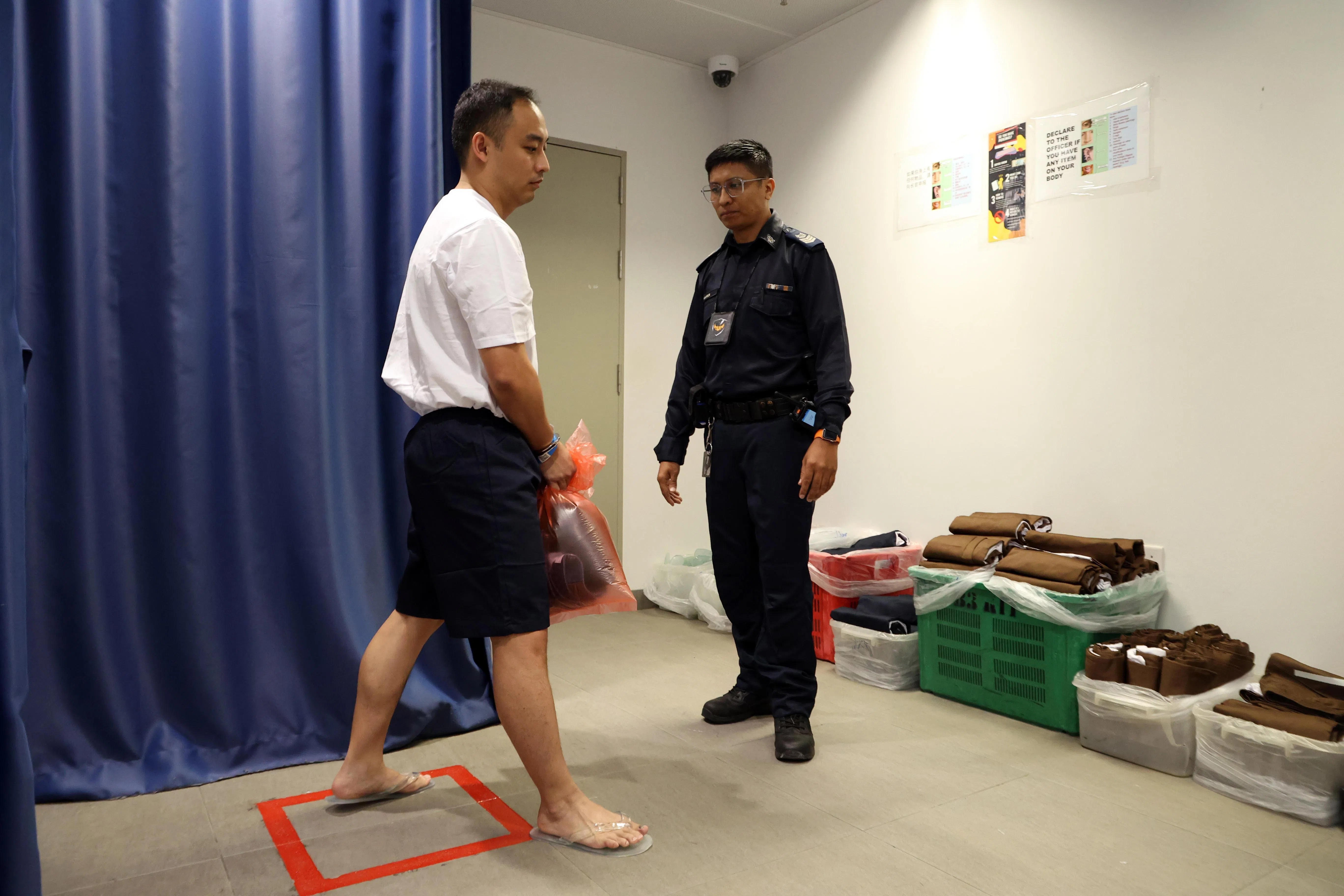 囚犯会换上囚衣，即白色上衣和蓝色短裤，以及透明人字拖。（邝启聪摄）