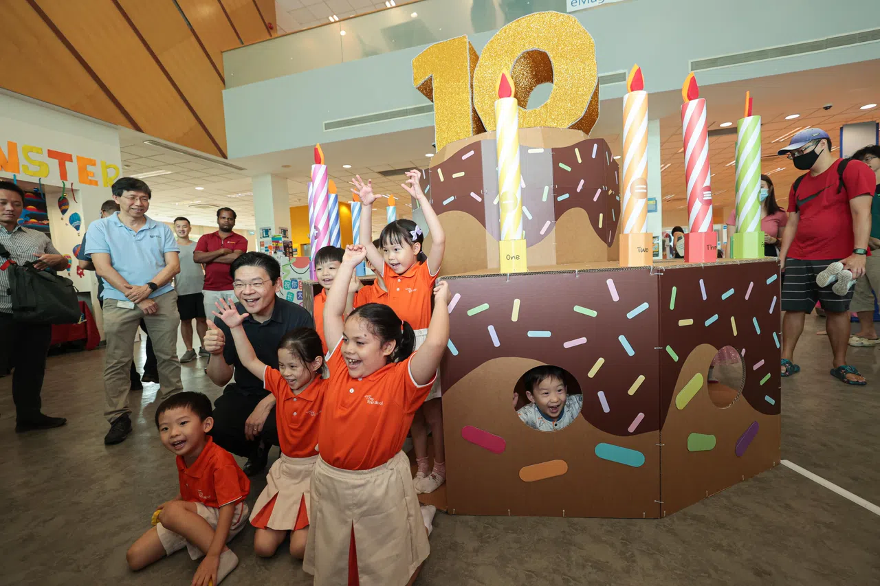 副总理兼财政部长黄循财于2023年6月4日参与《小小拇指》创刊10周年庆生活动，并同多名幼儿园学生在《小小拇指》巨型蛋糕模型前合影。（李冠卫摄）